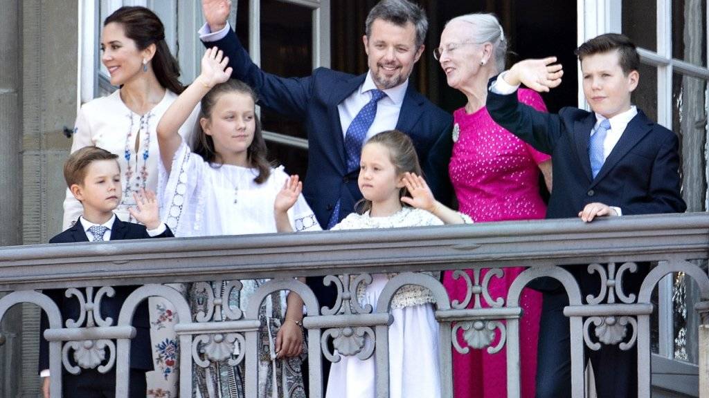 Der Jubilar winkt der Menge zu, umringt von seiner Familie, rechts von ihm Königin Margrethe und links seine Gattin Mary.