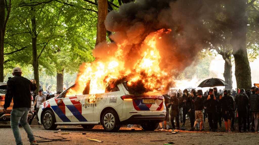 dpatopbilder - Bei einer Protestaktion gegen die aktuelle Asylpolitik in Den Haag wird ein Polizeiauto angezündet. Foto: Josh Walet/ANP/dpa