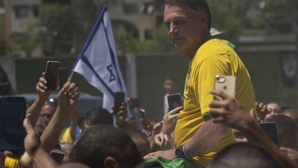 Jair Bolsonaro, ehemaliger Präsident von Brasilien, wird von Anhängern umringt, nachdem er an einer Wahlkampfveranstaltung teilgenommen hat. Foto: Silvia Izquierdo/AP/dpa