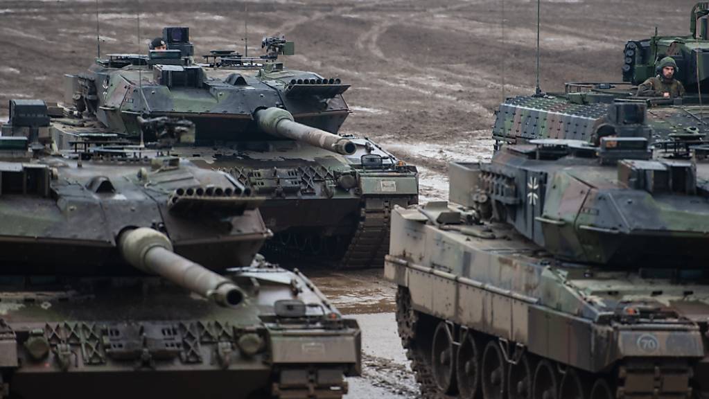 Drei Kampfpanzer der Bundeswehr vom Typ Leopard 2A6 und ein Schützenpanzer vom Typ Puma bei einer Übung im Gelände.