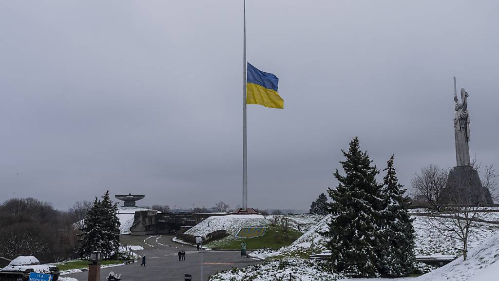 ARCHIV - Die ukrainische Flagge weht auf Halbmast in der Nähe der Mutter-Heimat-Statue in Kiew. Foto: Bernat Armangue/AP/dpa
