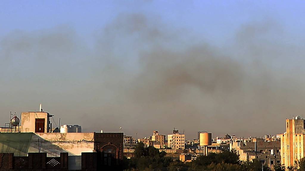 Nach einem Luftangriff steigt Rauch aus der Umgebung des internationalen Flughafens auf, gesehen von Sanaa, Jemen. Das israelische Militär gab an, die von den Huthis genutzte Infrastruktur des internationalen Flughafens von Sanaa sowie Häfen in Hodeida, Al-Salif und Ras Qantib sowie Kraftwerke ins Visier genommen zu haben. Foto: Osamah Abdulrahman/AP/dpa