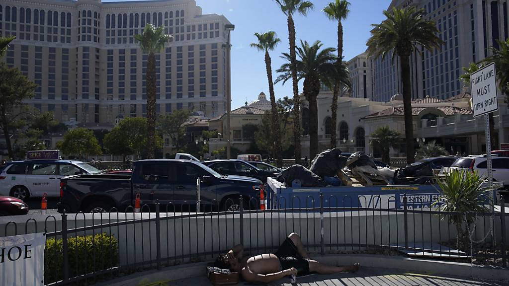 Ein Mann liegt in der Hitze in Las Vegas im Halbschatten des Las Vegas Strip. Foto: John Locher/AP/dpa