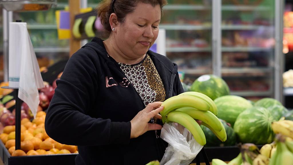 Eine Person kauft Bananen: die Inflation in der Eurzone hat angezogen (Symbolbild).