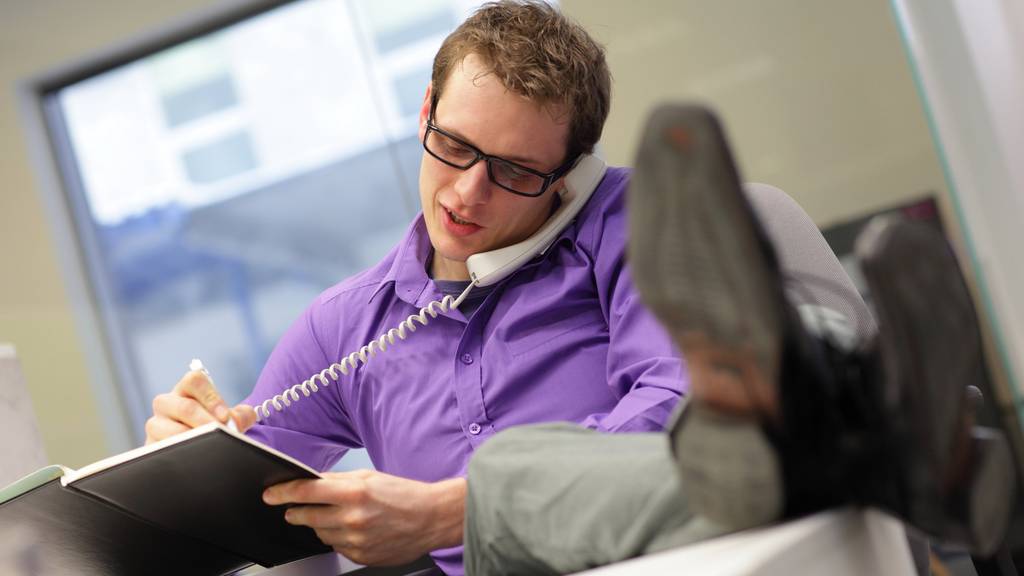 young caucasian businessman on phone - bad sitting posture