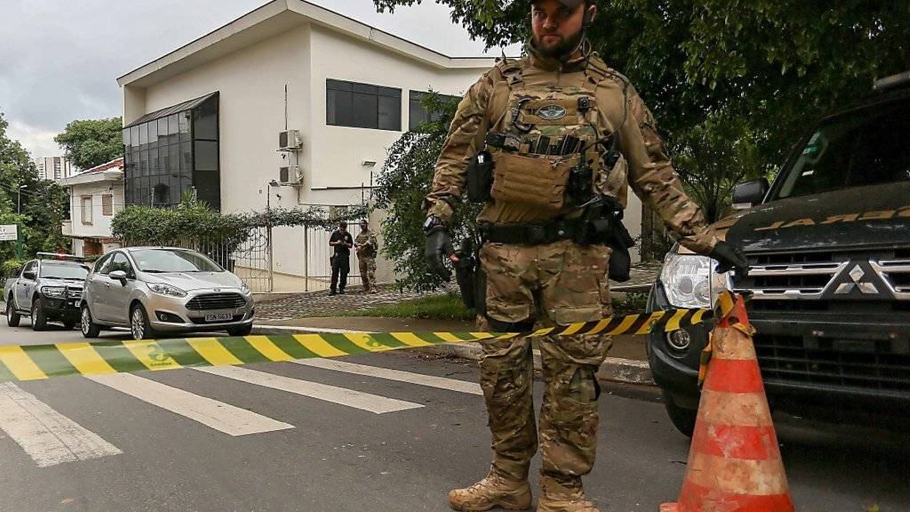 Ein Polizist vor dem Haus vom früheren brasilianischen Präsidenten Lula, das am Freitag durchsucht wurde.