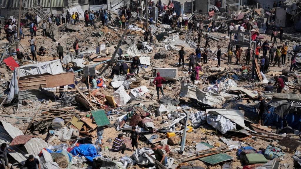 ARCHIV - Palästinenser sammeln Habseligkeiten aus einer Schule, die als Unterkunft für Vertriebene diente und am Dienstag zweimal von der israelischen Armee angegriffen wurde, wobei mehrere Menschen getötet wurden. Foto: Abdel Kareem Hana/AP/dpa