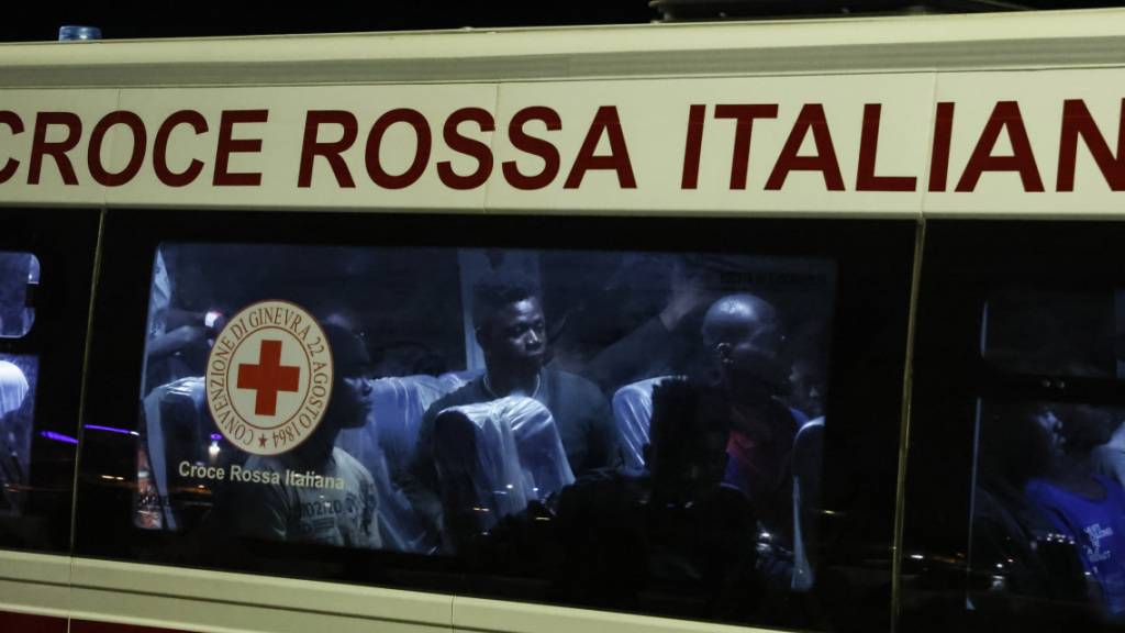 Gerettete Menschen sitzen in einem Bus, nachdem sie auf Lampedusa von einem Boot gestiegen sind. Foto: Cecilia Fabiano/LaPresse via AP/dpa - ACHTUNG: Nur zur redaktionellen Verwendung und nur mit vollständiger Nennung des vorstehenden Credits