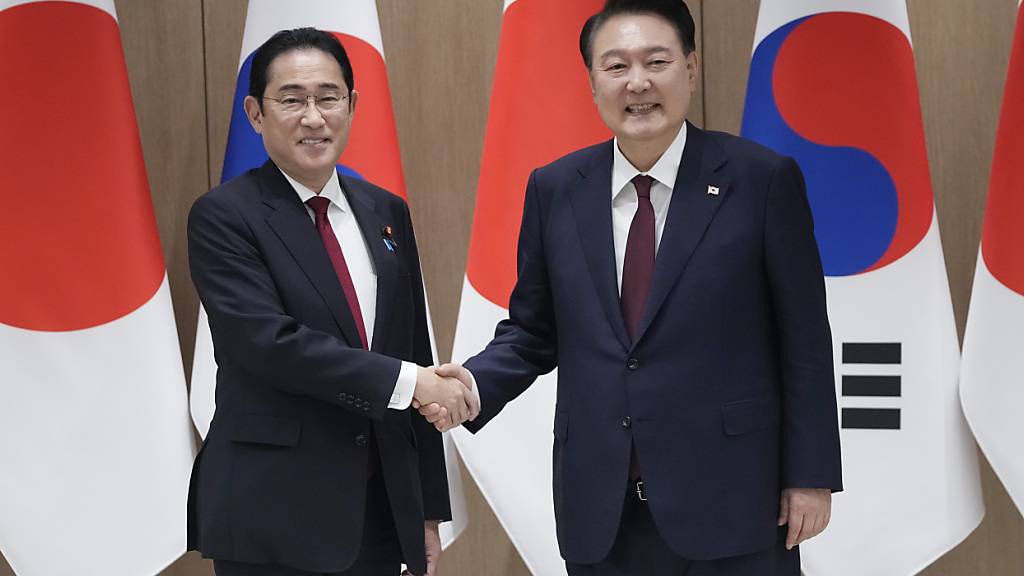 Der südkoreanische Präsident Yoon Suk Yeol, rechts, schüttelt dem japanischen Ministerpräsidenten Fumio Kishida während eines Treffens im Präsidialamt die Hand. Foto: Ahn Young-joon/Pool AP/dpa