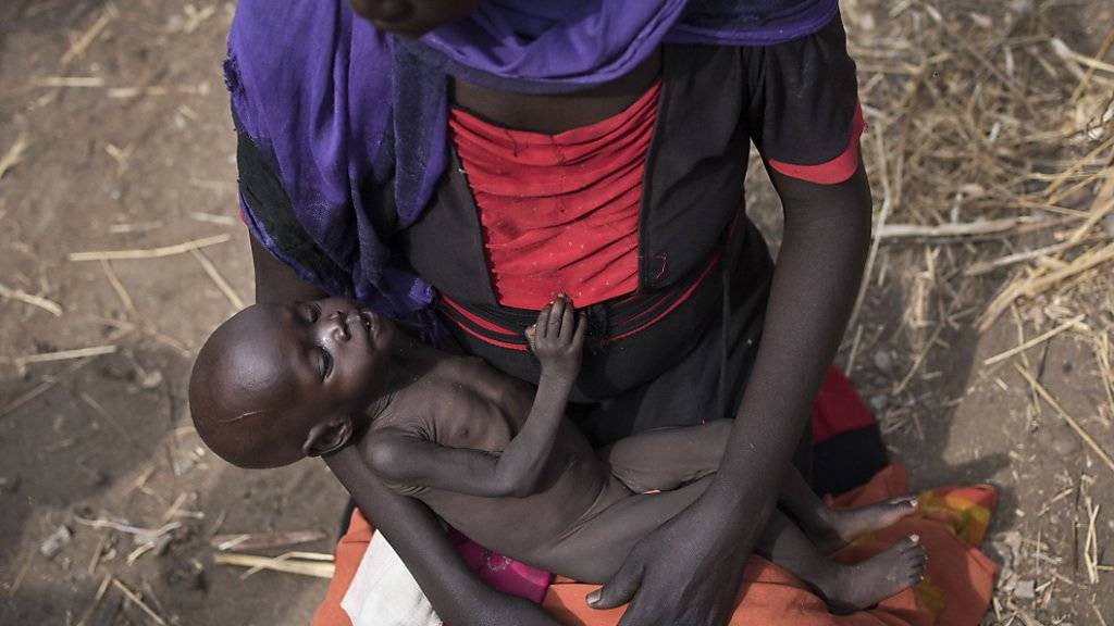 Eine süsudanesische Mutter wartet mit ihrer Tochter an einer Nahrungsmittelverteilstelle auf Essen. Etwa die Hälfte der Bevölkerung im Südsudan hat nicht genug zu essen. (Archiv)