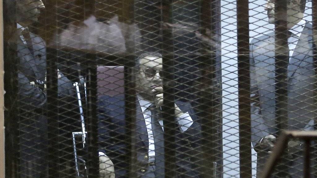 Mubarak bei einer Gerichtsverhandlung in einem Korruptionsverfahren im vergangenen Mai, flankiert von seinen Söhnen Gamal (l) und Alaa