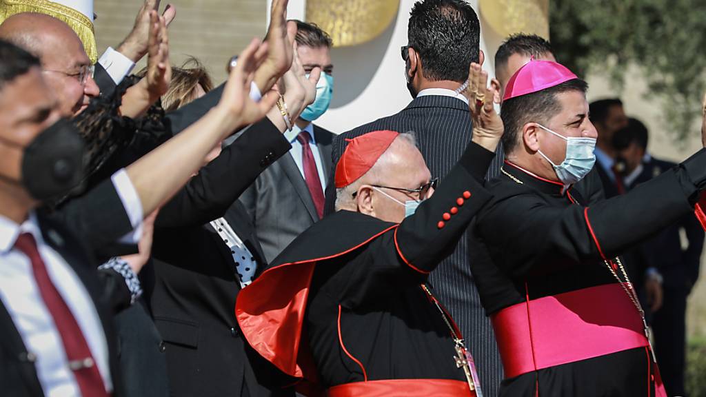 Barham Saleh (2.v.l), Präsident des Irak, und hochrangige Vertreter der katholischen Kirche winken Papst Franziskus während seiner Abflugzeremonie auf dem Internationalen Flughafen zu. Foto: Ameer Al Mohammedaw/dpa