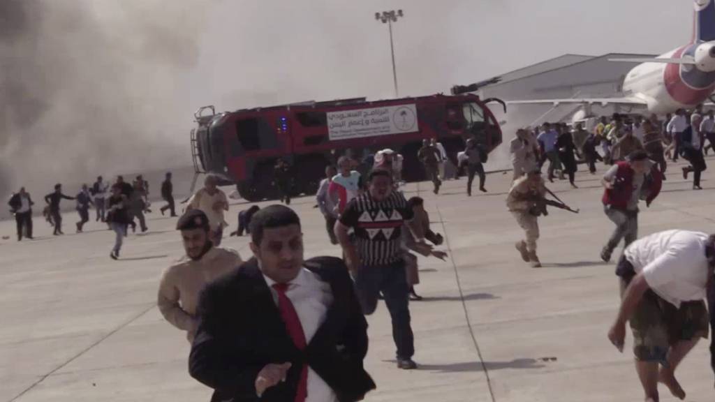 Menschen rennen nach einer schweren Explosion über den Flughafen. Der Vorfall ereignete sich Zeugenberichten zufolge kurz nach der Landung eines aus Saudi-Arabien kommenden Flugzeuges mit der neuen Regierung des Jemens. Foto: --/AP/dpa