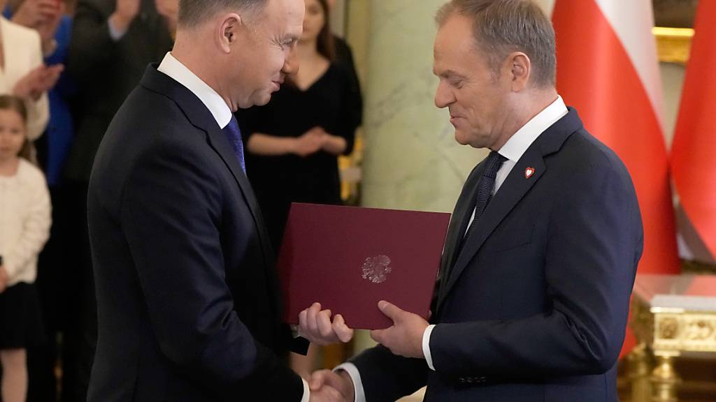 dpatopbilder - Andrzej Duda (l) und Donald Tusk geben sich die Hand während der Vereidigung der neuen Regierung im Präsidentenpalast. Polens Regierungschef Donald Tusk hat Präsident Andrzej Duda vorgeworfen, die Inhaftierung von zwei rechtskräftig verurteilten Abgeordneten der abgelösten nationalkonservativen Regierungspartei PiS zu behindern. Foto: Czarek Sokolowski/AP/dpa