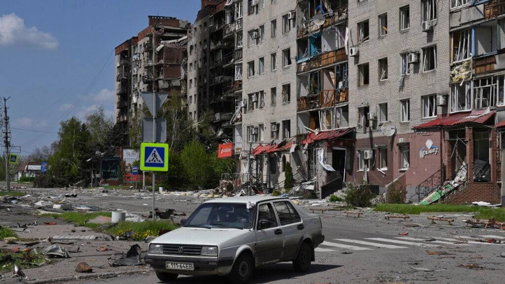 ARCHIV - Ein verlassenes Auto steht vor dem Hintergrund beschädigter Gebäude im Zentrum von Pokrowsk, dem Schauplatz der schwersten Gefechte mit den russischen Truppen in der Region Donezk. Foto: Michael Shtekel/AP/dpa/Archivbild