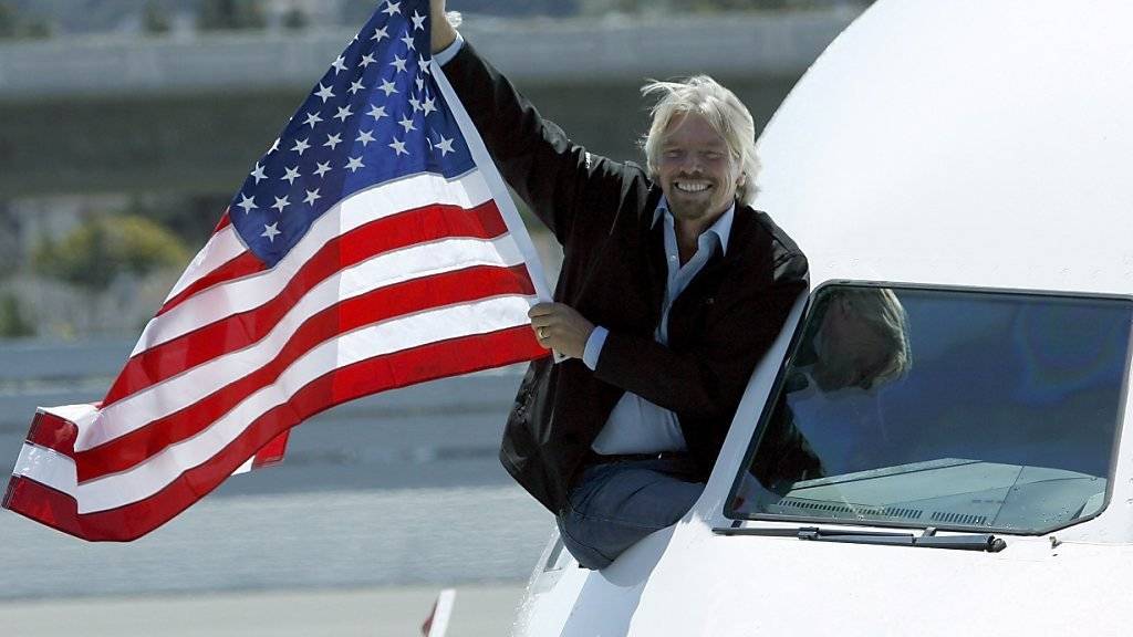 Alaska Air kauft seine Fluggesellschaft: Richard Branson hält eine US-Flagge aus dem Fenster eines Virgin-America-Fliegers.