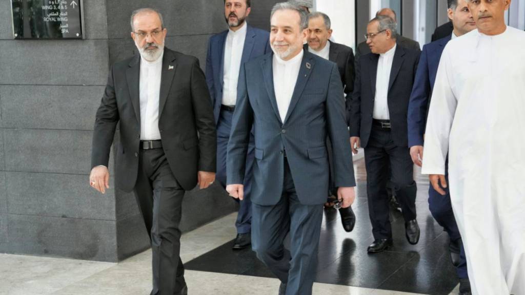 HANDOUT - Auf diesem vom iranischen Außenministerium über AP veröffentlichten Foto begibt sich der iranische Außenminister Abbas Araghtschi  (M) zum Ort der Gespräche zwischen dem Iran und den USA. Foto: -/Iranian Foreign Ministry/dpa - ACHTUNG: Nur zur redaktionellen Verwendung und nur mit vollständiger Nennung des vorstehenden Credits