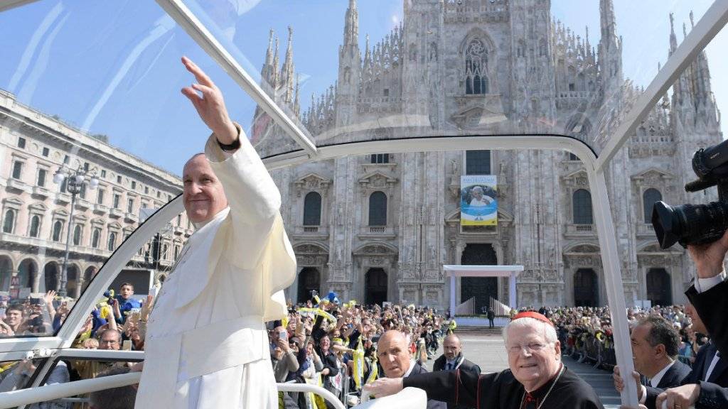 Der Papst winkt Gläubigen vor dem Mailänder Dom.