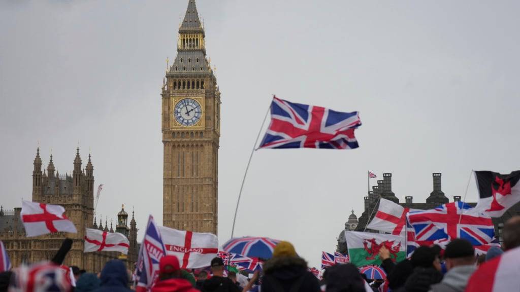Demonstranten gehen über die Westminster Bridge. Der britische Rechtsextremist Tommy Robinson hatte zu dem Marsch und der Kundgebung unter dem Motto «Unite the Kingdom» aufgerufen. Foto: Joanna Chan/AP/dpa