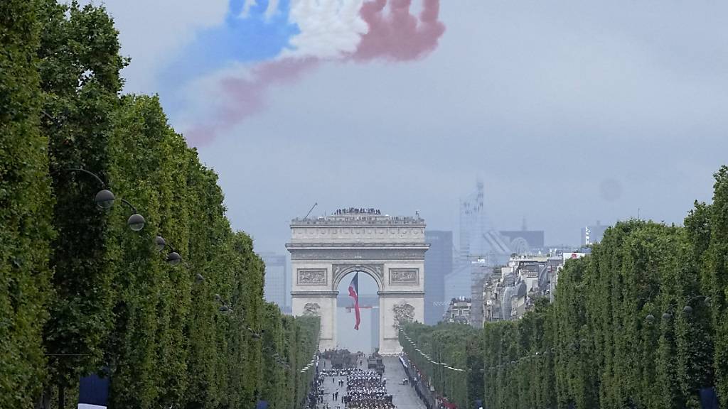 Jets der offiziellen Kunstflugstaffel der französischen Luftwaffe fliegen bei der Militärparade zum Tag der Bastille über die Champs-Élysées. Foto: Michel Euler/Pool AP/dpa