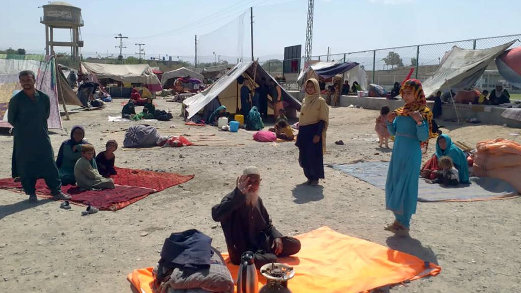 Afghanische Familien sitzen vor ihren Zelten am Rande von Chaman, einer Grenzstadt in der südwestlichen pakistanischen Provinz Belutschistan. Foto: Jafar Khan/AP/dpa