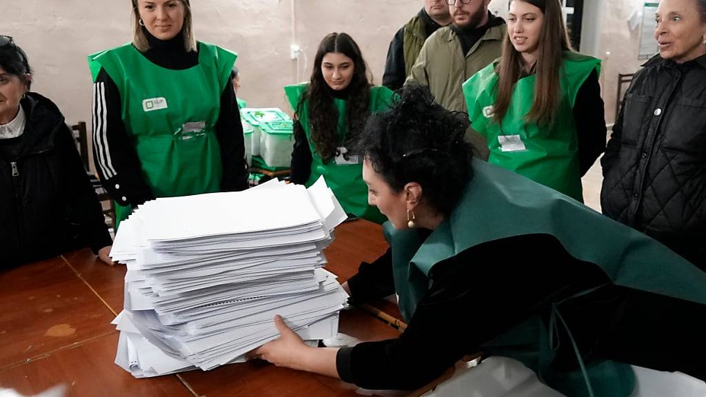 Mitglieder einer Wahlkommission bereiten sich nach den Parlamentswahlen in Georgien auf die Auszählung der Stimmzettel in einem Wahllokal in Tiflis vor. Foto: Kostya Manenkov/AP/dpa