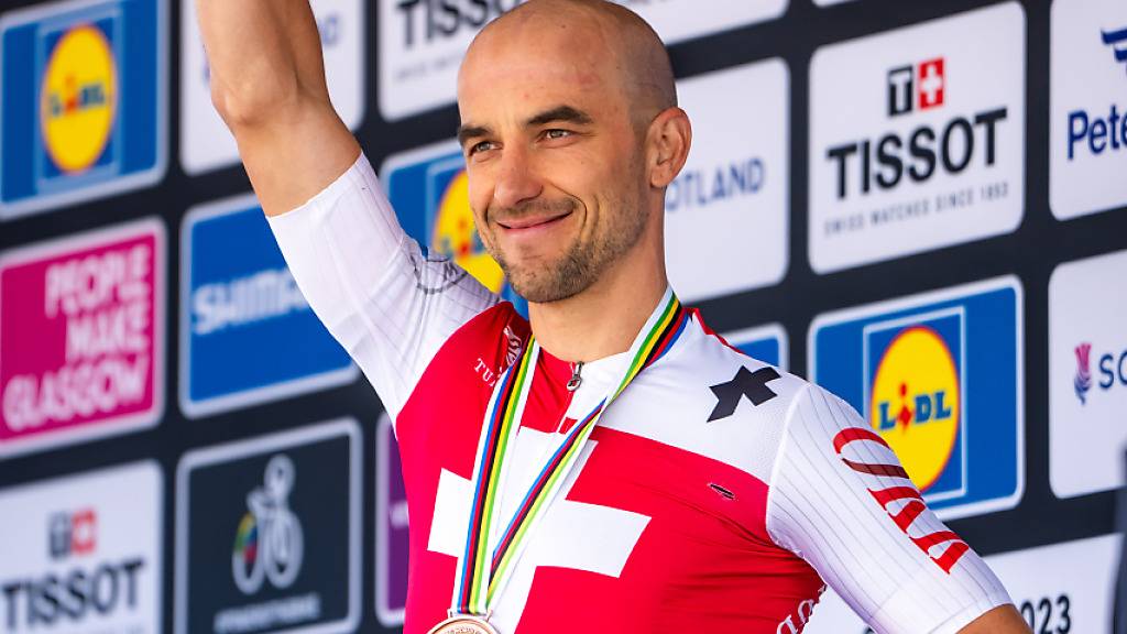 Mountainbiker Nino Schurter mit der Bronzemedaille um den Hals winkt bei der Siegerehrung dem Publikum zu