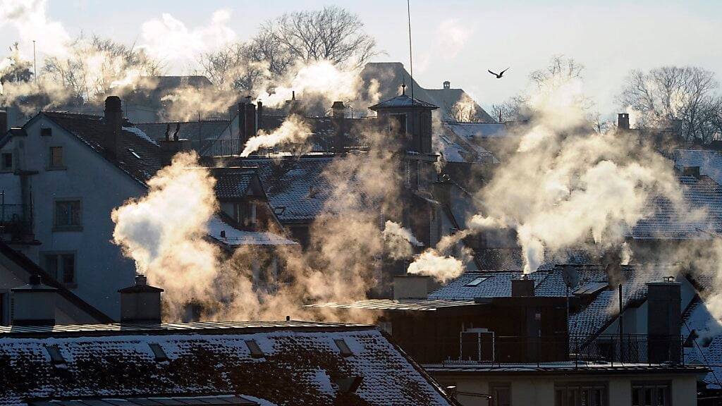 Rauch steigt aus Schornsteinen auf an einem frostigen Morgen. In der Nacht auf Samstag sind in der Schweiz die bisher tiefsten Temperaturen des Winters gemessen worden. (Symbolbild)