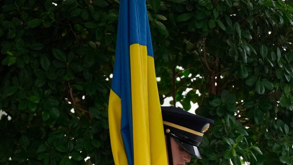 Eine militärische Ehrengarde hält eine Flagge in den Farben der Ukraine vor dem Treffen von US-Präsident Trump und dem ukrainischen Präsidenten Selenskyj am Weißen Haus. Foto: Julia Demaree Nikhinson/AP/dpa