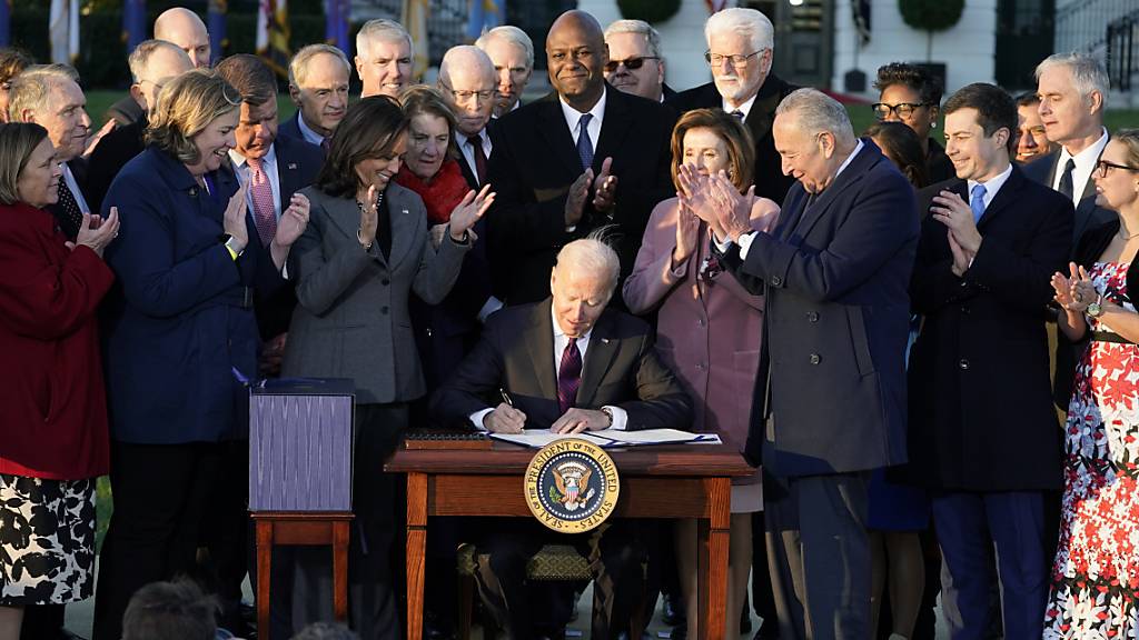 Joe Biden, Präsident der USA, unterzeichnet während einer Zeremonie auf dem South Lawn des Weißen Hauses das Infrastrukturgesetz. Foto: Evan Vucci/AP/dpa