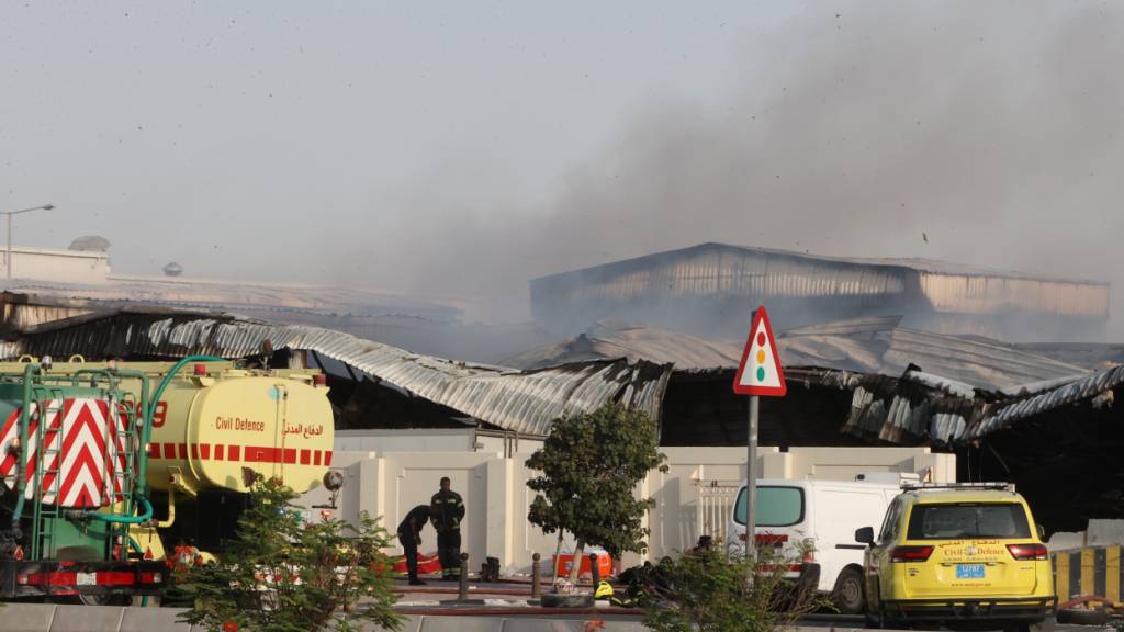 Feuerwehrleute arbeiten vor einem beschädigten Lagerhaus in einem Industriegebiet nach einem iranischen Angriff. Foto: Uncredited/AP/dpa