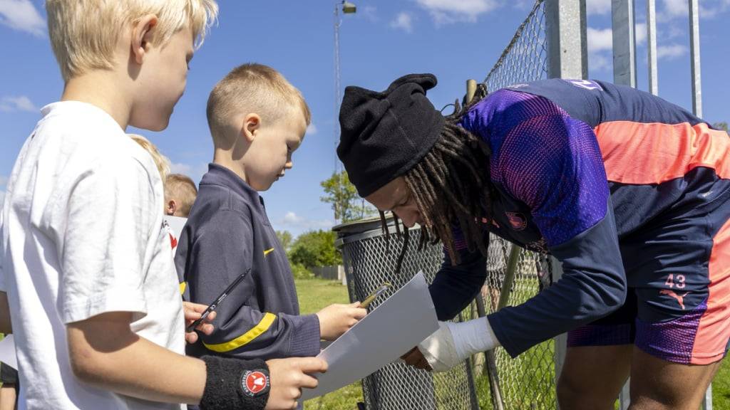 Bei den Kindern beliebt: Kevin Mbabu schreibt auf dem Trainingsgelände des FC Midtjylland Autogramme