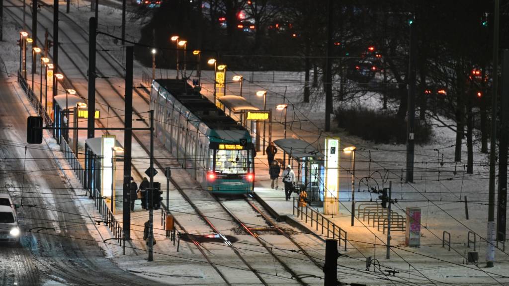 ARCHIV - Nahe des Alexanderplatzes liegt noch Schnee auf den Straßen und zwischen den Schienen, während eine Tram kommt und Fußgänger unterwegs sind. Foto: Annette Riedl/dpa