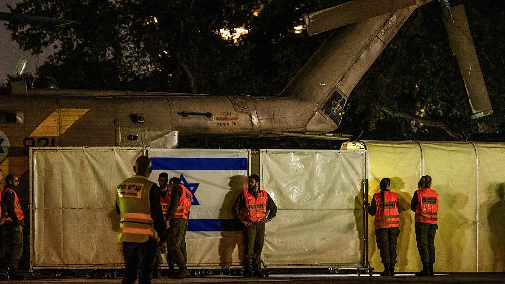 Sicherheitskräfte schirmen den Blick ab, nachdem ein Hubschrauber mit von Hamas-Kämpfern freigelassenen Geiseln auf dem Schneider Children's Medical Center of Israel gelandet ist. Foto: Ilia Yefimovich/dpa