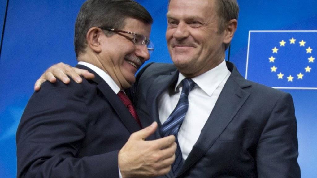 Der türkische Ministerpräsident Ahmet Davutoglu (links) in freundschaflicher Umarmung mit EU-Ratspräsident Donald Tusk. Davutoglu ist sichtlich zufrieden nach dem Gipfeltreffen EU-Türkei am Sonntag in Brüssel.