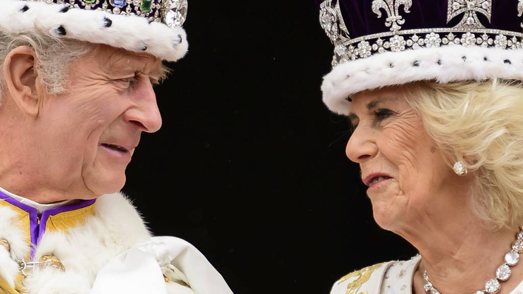 ARCHIV - König Charles III. und Königin Camilla sehen sich an, als sie nach ihrer Krönung auf dem Balkon des Buckingham-Palastes stehen. Foto: Leon Neal/AP/dpa