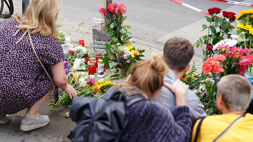 Nach einem Strassenverkehrsunfall mit vier Toten legten Anwohner in Berlin Blumen auf den Gehweg und stellten Kerzen auf.