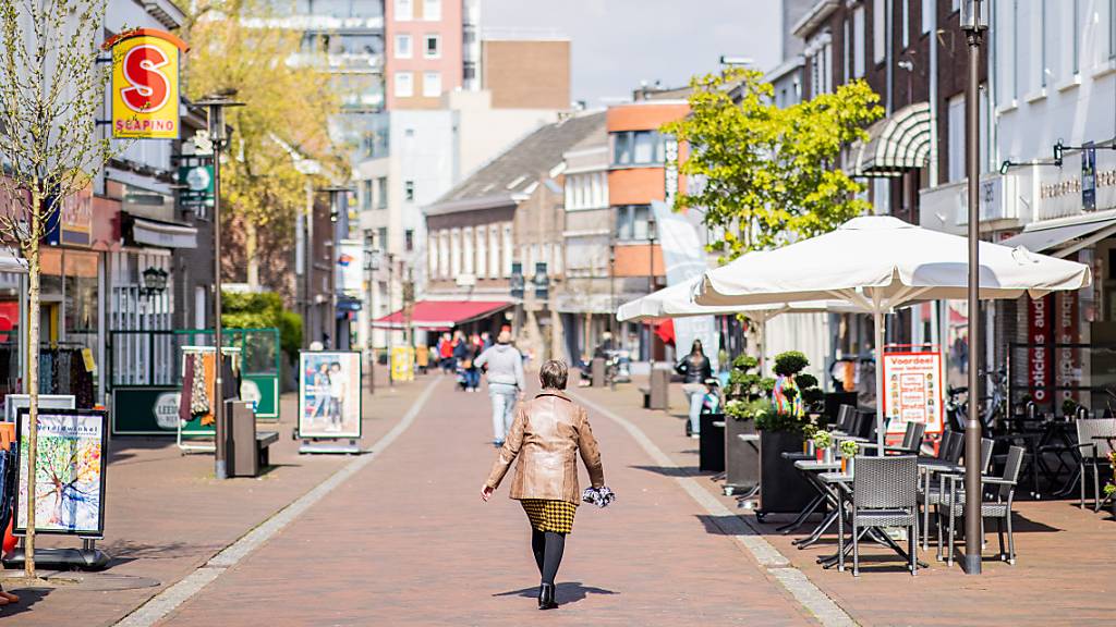 Menschen gehen durch die Innenstadt der niederländischen Grenzstadt Kerkrade. Foto: Marcel Kusch/dpa