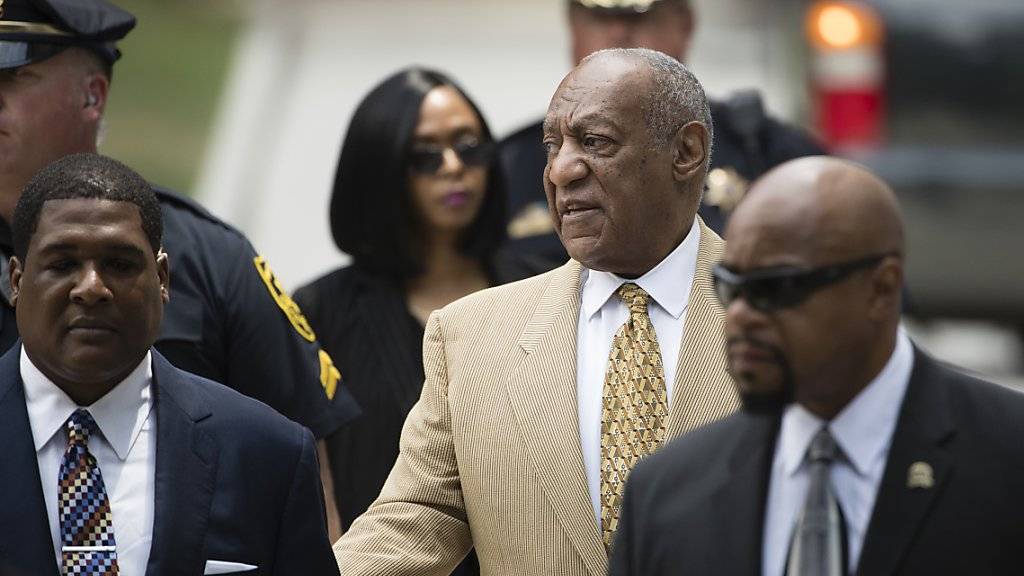 Der praktisch blinde Bill Cosby (M) lässt sich von einem seiner Anwälte in den Gerichtssaal führen. (Archivbild 7.7.)