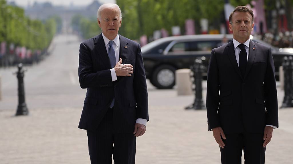 Joe Biden (l), Präsident der USA, und Emmanuel Macron, Präsident von Frankreich, kommen zur Kranzniederlegung am Grab des Unbekannten Soldaten unter dem Arc de Triomphe. Foto: Evan Vucci/AP/dpa