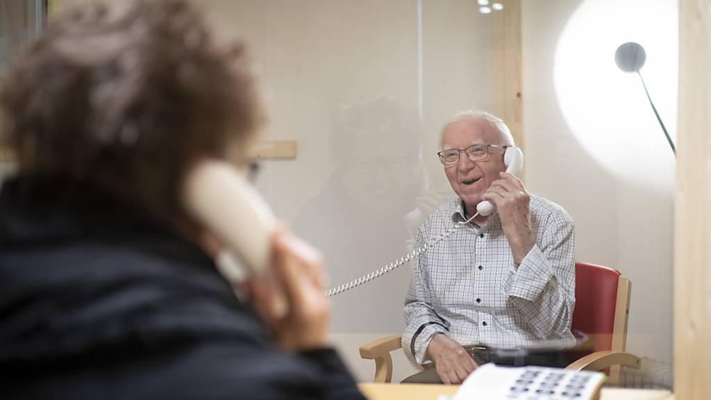 Der 88-jährige Eugen Studach erhält Besuch von Tochter Barbara Castelberg, in der Besucherbox des Altersheims Risi in Wattwil SG. Dank der «Bsuechsbox» können sich Angehörige und Bewohner trotz der Coronavirus-Pandemie treffen und über das Telefon miteinander plaudern.