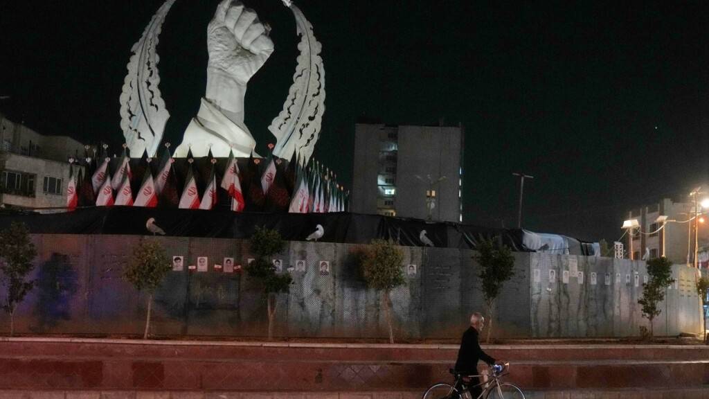 Ein Mann schiebt auf dem Platz der Islamischen Revolution in Teheran sein Fahrrad vor einem Denkmal. Foto: Vahid Salemi/AP/dpa