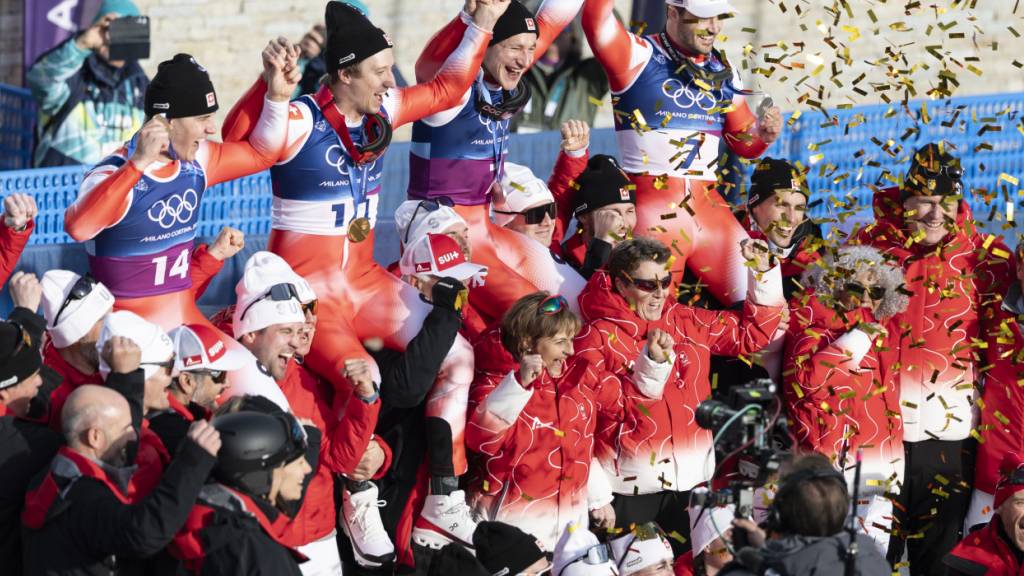 Franjo von Allmen und Tanguy Nef, die Olympiasieger in der Team-Kombi, lassen sich gemeinsam mit dem Silber-Duo Marco Odermatt/Loïc Meillard feiern