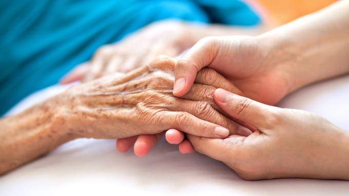 Spitex-Pfleger zieht Patientin während Handmassage Ringe von Fingern