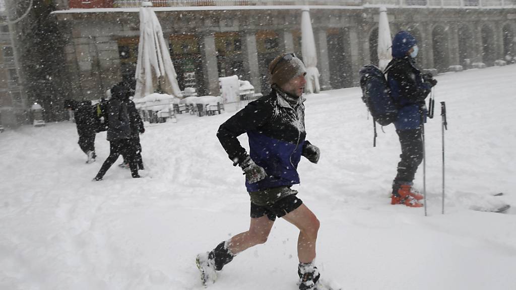 dpatopbilder - Ein Mann läuft durch den Schnee auf der Plaza Mayor. Das Sturmtief «Filomena» sorgt landesweit für Rekordkälte und viel Schnee. Laut des Wetterdienstes AEMET gab es solch einen Schneefall das letzte Mal im Februar 1984. Foto: Andrea Comas/AP/dpa