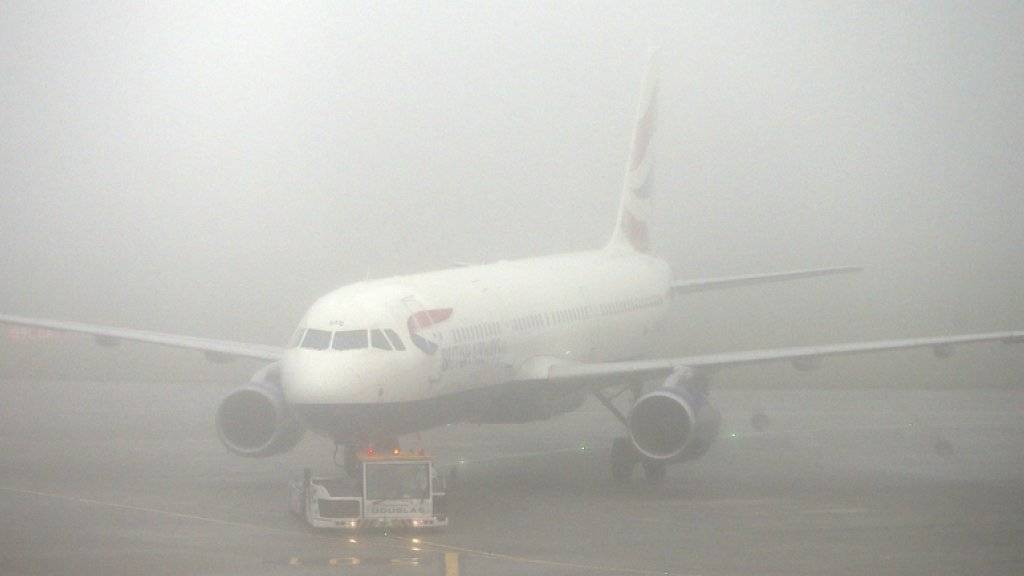 Ein Flugzeug der British Airways steht am Montag in dichtem Nebel auf dem Heathrow Airport in London.