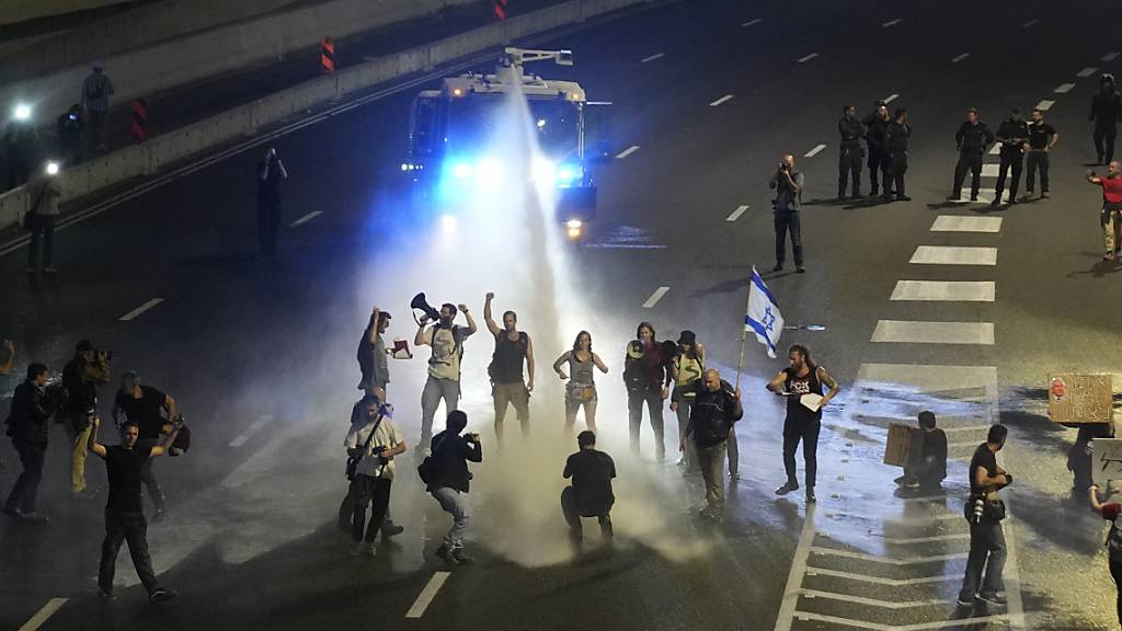 Die Polizei setzt einen Wasserwerfer ein, um Demonstranten von einer Autobahn in Tel Aviv zu vertreiben. Foto: Maya Alleruzzo/AP/dpa