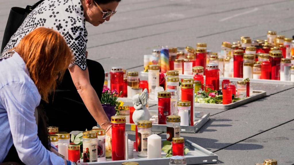 Menschen zünden auf dem Hauptplatz Kerzen an, nachdem ein ehemaliger Schüler am Vortag in einer Schule mehrere Menschen tötete und viele weitere verletzte, bevor er sich das Leben nahm. Foto: Darko Bandic/AP/dpa