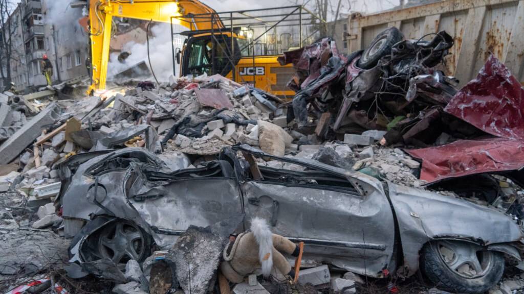 ARCHIV - Rettungskräfte räumen die Trümmer eines Wohnhauses nach einem russischen Raketenangriff in Charkiw. Foto: Andrii Marienko/AP/dpa (Archivbild)