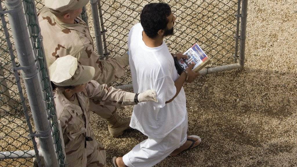 Ein Gefangener wird im Gefangenenlager von Guantanamo von US-Armeeangehörigen eskortiert. (Archivbild)